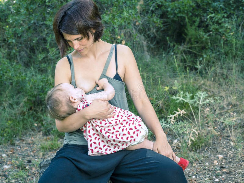 Young mother breastfeeding a baby in nature. stock images Young mother breastfeeding a baby in nature. stock images