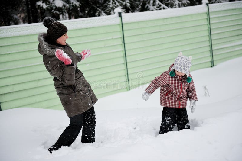 Young mother and daughter have fun in the snow