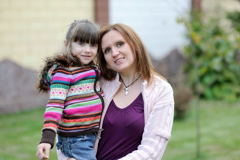 Young mother with her daughter in the garden