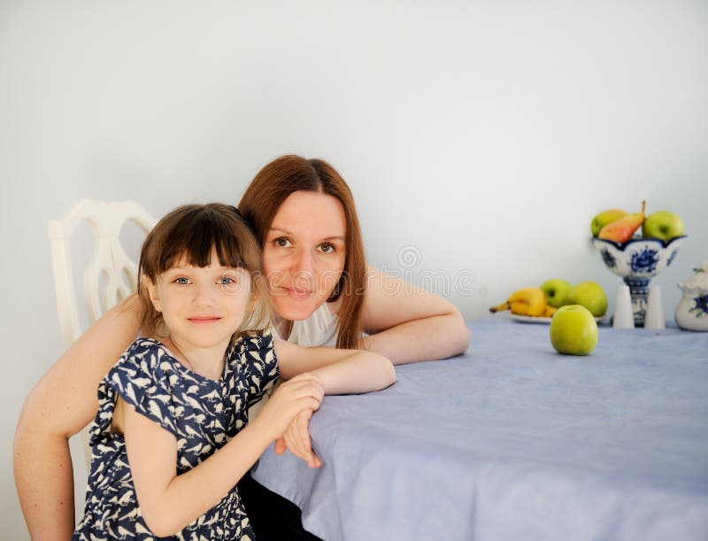Young mother with her little daughter in kitchen