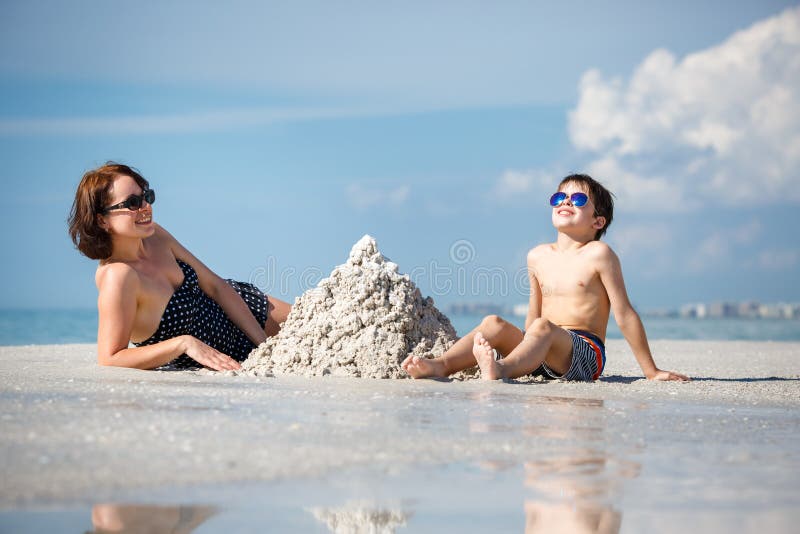 Young mother and her little son building sand castle at beach on Florida