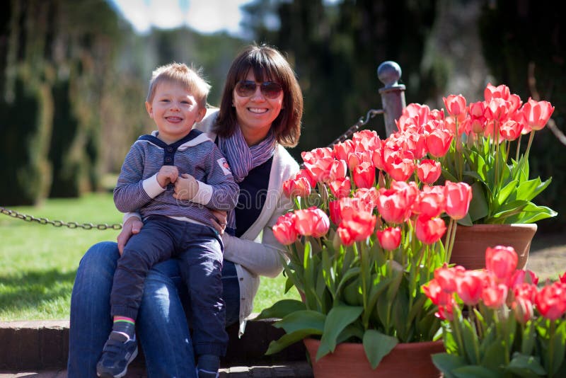 Young mother and her little son in a tulip garden