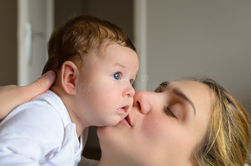 Young mother kissing her adorable baby boy. 