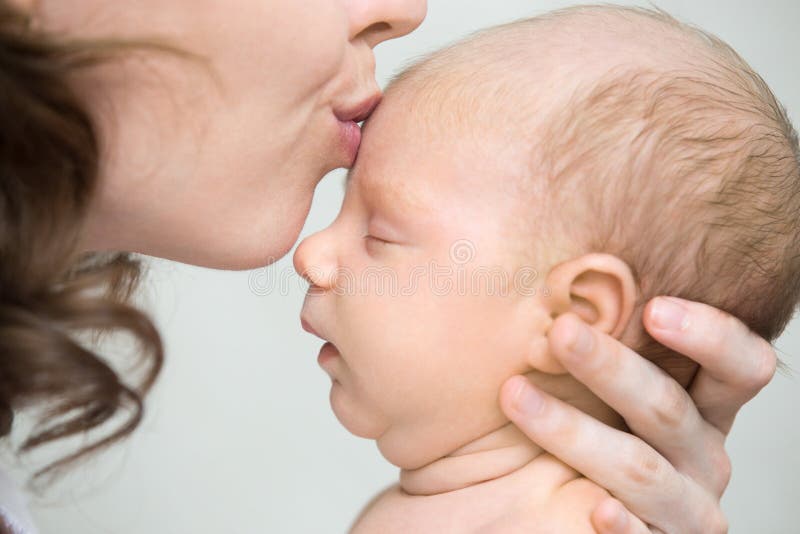 Young mother kissing her newborn baby. Close-up royalty free stock image Young mother kissing her newborn baby. Close-up royalty free stock image
