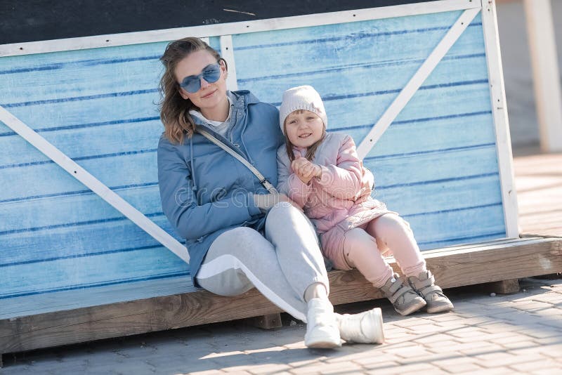 Young Mother And A Little Daughter Walk. Mom Hugs Daughter. stock photo Young Mother And A Little Daughter Walk. Mom Hugs Daughter. stock photo