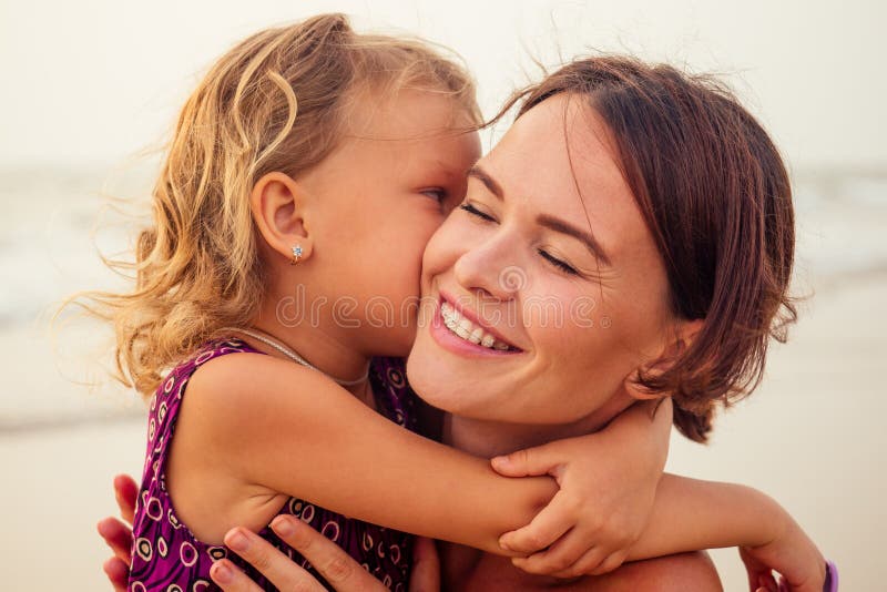 Young mother with little girl on her back at beach in summer. Happy family having fun summer vacation royalty free stock photo Young mother with little girl on her back at beach in summer. Happy family having fun summer vacation royalty free stock photo