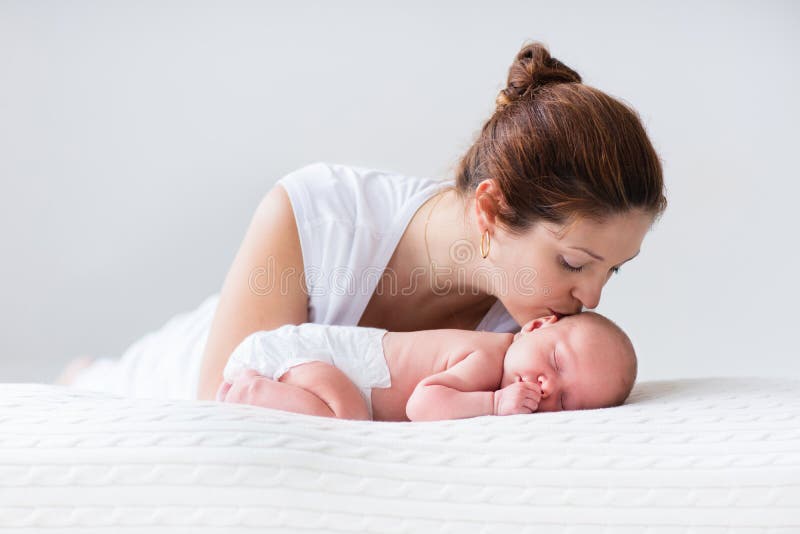 Giovane madre che abbraccia il suo bambino neonato.