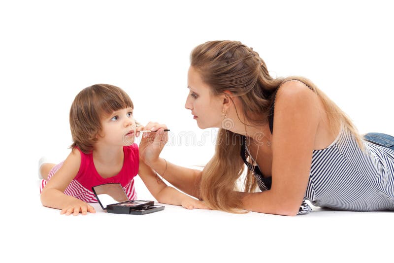 Young mother paints lipstick little daughter