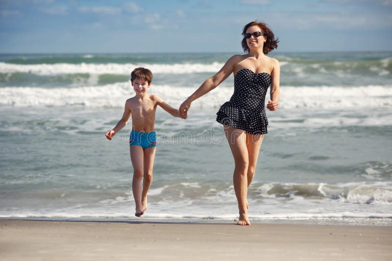 Young mother and son playing on the beach. 