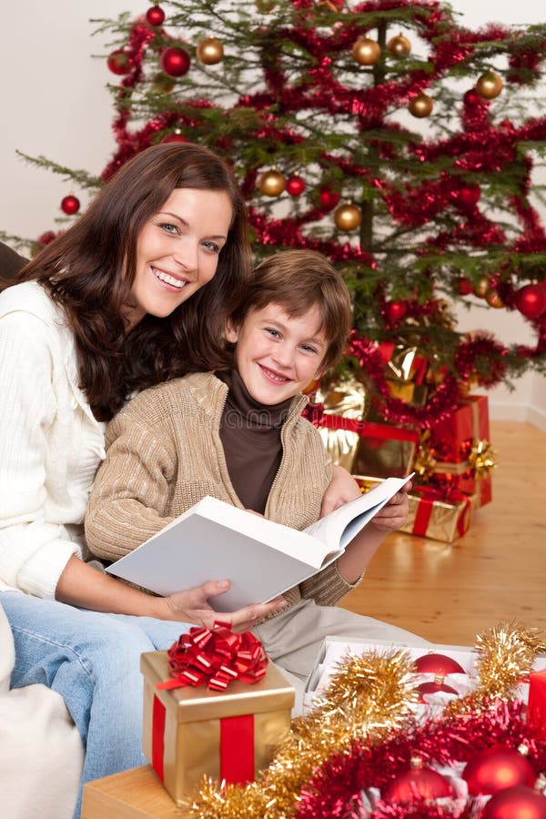 Young mother with son reading book on Christmas