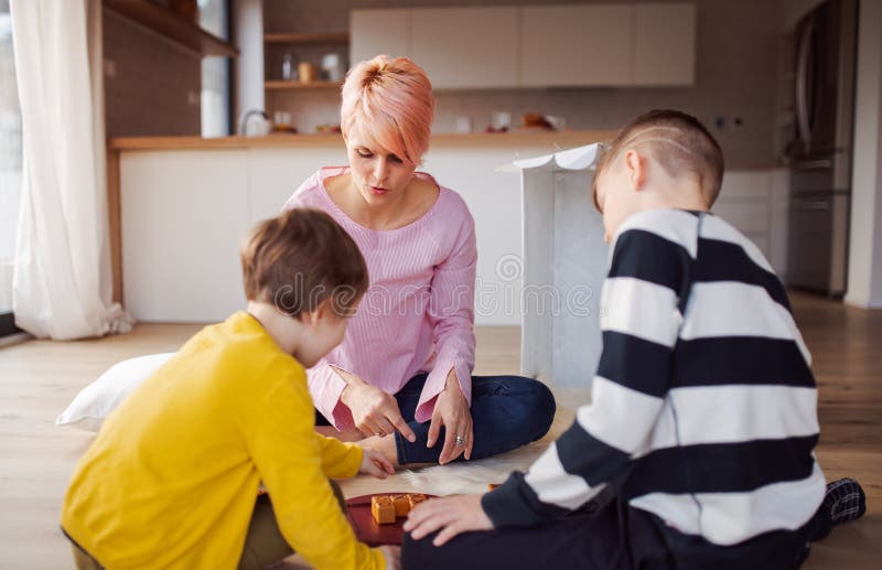 Young Mother with Two Children Playing Board Games on the Floor. Stock Photo Image of floor