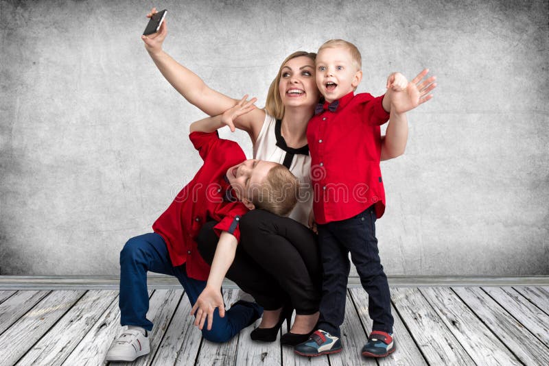 A Young Mother With Two Sons Making Selfie On Mobile PhoneSpring