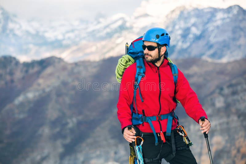 Young Mountaineer Standing with Backpack on Top of a Mountain Stock