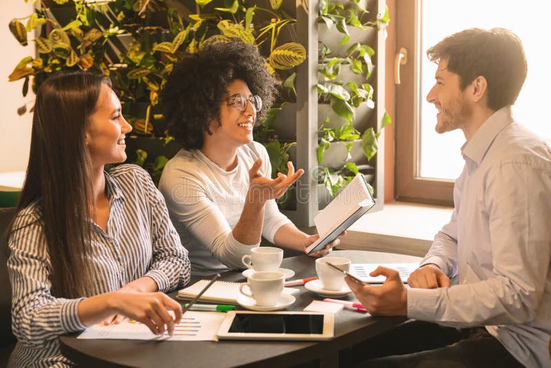 Young multiethnic business team sharing ideas in cafe stock image Young multiethnic business team sharing ideas in cafe stock image