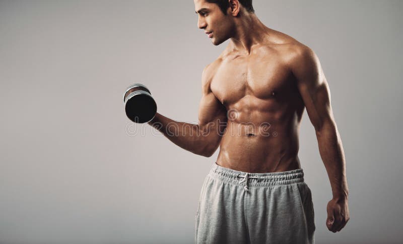 Young muscular man exercising with dumbbells