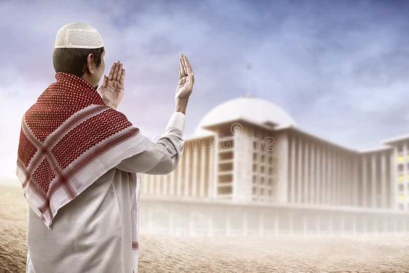 Young muslim man praying looking to mosque royalty free stock images Young muslim man praying looking to mosque royalty free stock images