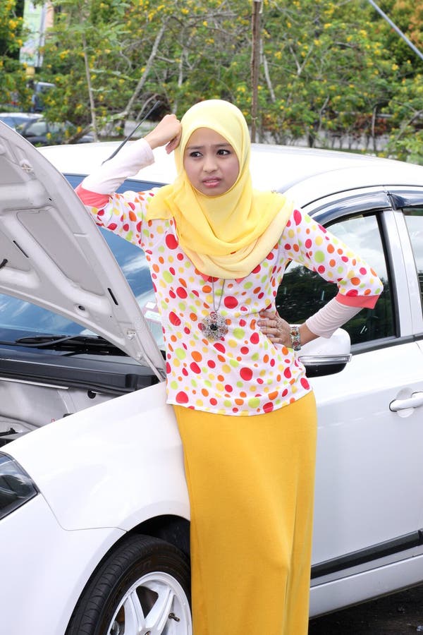 Young muslim woman checking engine stock image Young muslim woman checking engine stock image