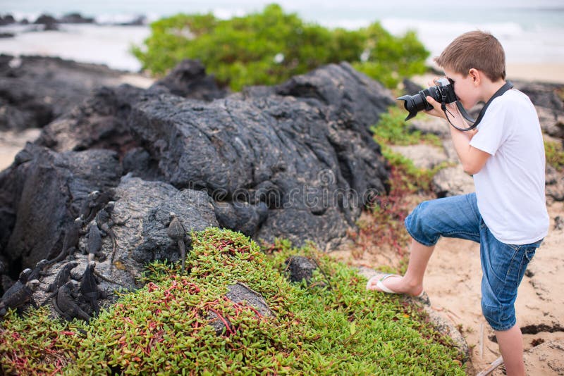 Malý chlapec fotografovanie morský na sopečný skaly.
