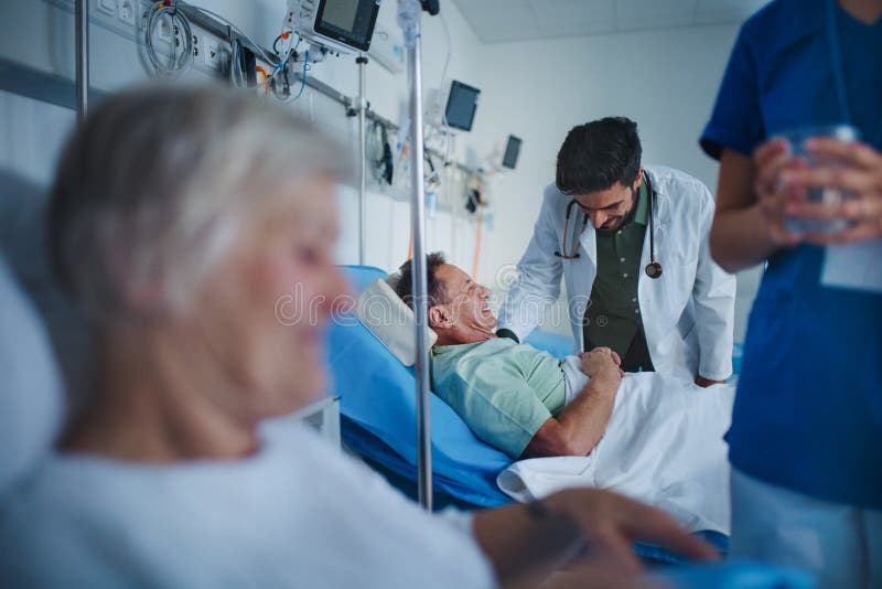 Young Nurse Giving Glass Of Water To Senior Patient Doctor Laughing