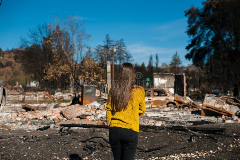 Woman lookinh at her burned home after fire disaster stock photos Woman lookinh at her burned home after fire disaster stock photos