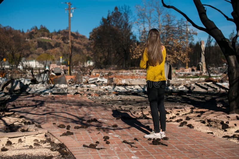Woman looking at her burned home after fire disaster stock image Woman looking at her burned home after fire disaster stock image