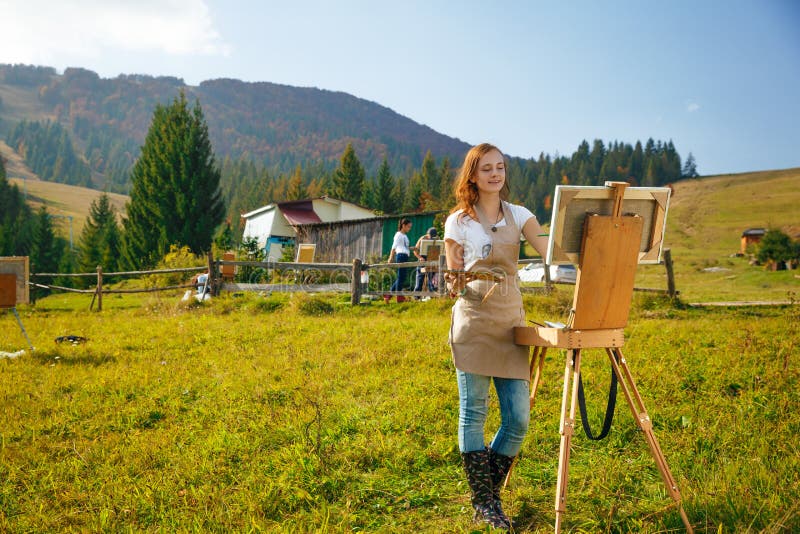 Young painter at work in the mountains