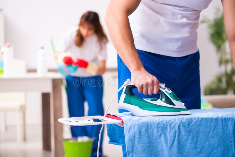 Young pair doing clothing ironing at home