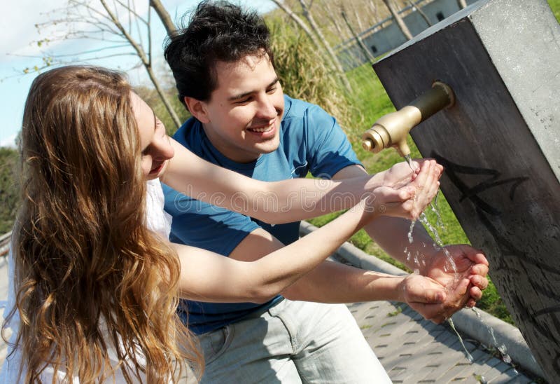 Young pair near a drinking fountain with water