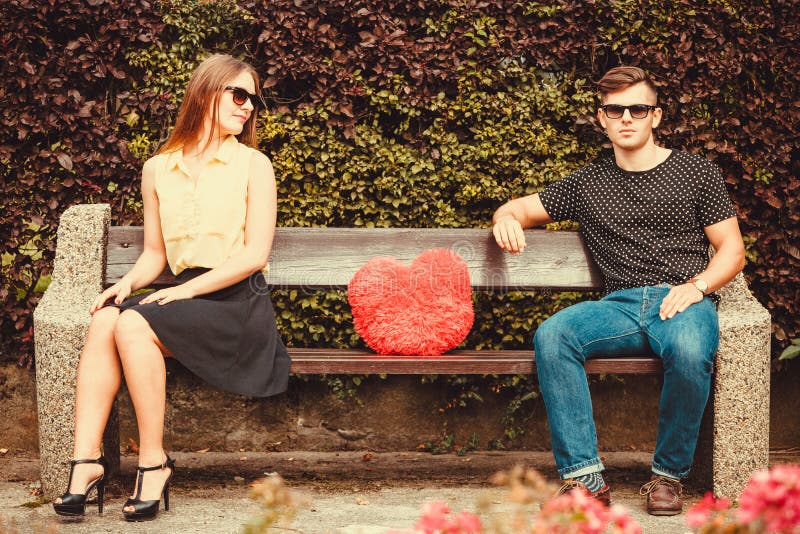 Young pair sitting on bench.