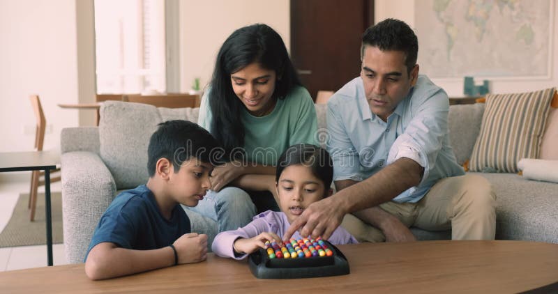 Young parents and children play rainbow balls boardgame
