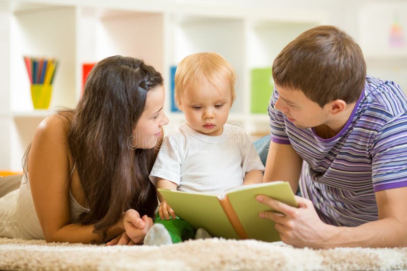 Young parents mom and dad reading children book to stock photography Young parents mom and dad reading children book to stock photography