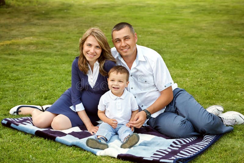 Young parents with son in the summer. Mom, dad and child stock photo Young parents with son in the summer. Mom, dad and child stock photo