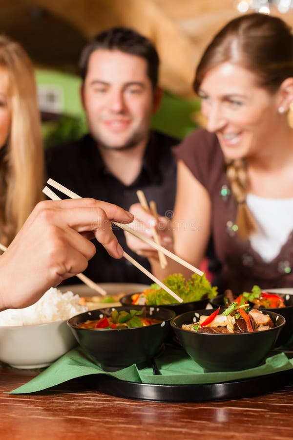 Young People Eating in Thai Restaurant Stock Image - Image of dishes