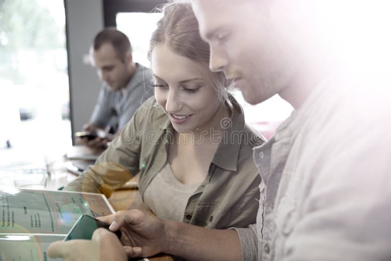 Young People Having a Break in a Snack Bar Sharing Information on a