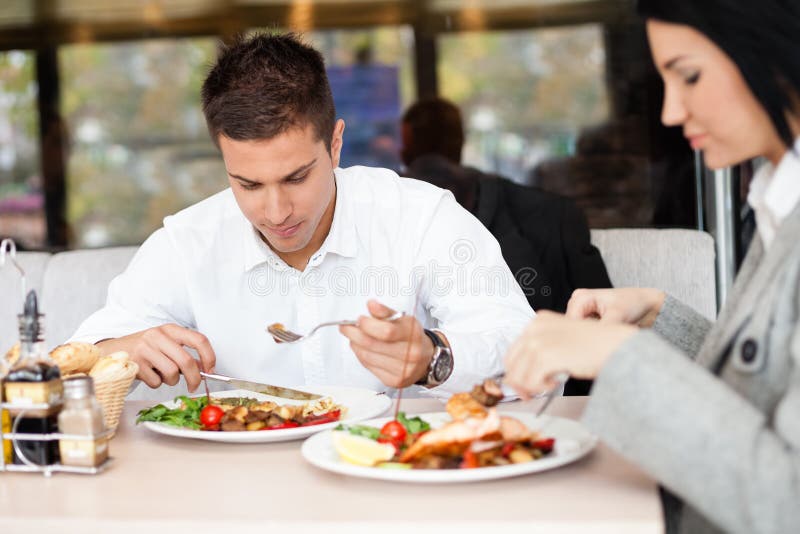 Young people or businesspeople having lunch at restaurant. Young people or businesspeople having lunch at restaurant