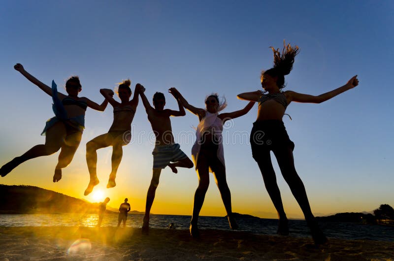 Young people jumping on the beach stock photo Young people jumping on the beach stock photo