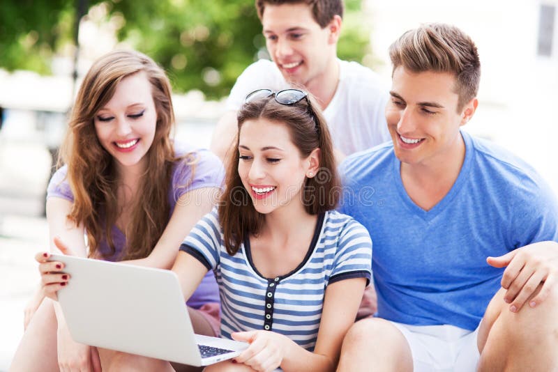 Young people with laptop outdoors stock photos