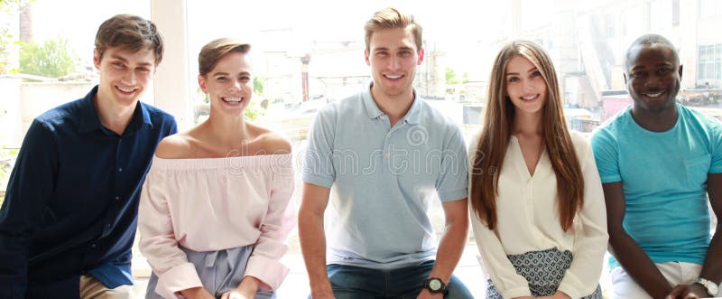 Young people looking at camera with smile while sitting in the office. stock photography Young people looking at camera with smile while sitting in the office. stock photography