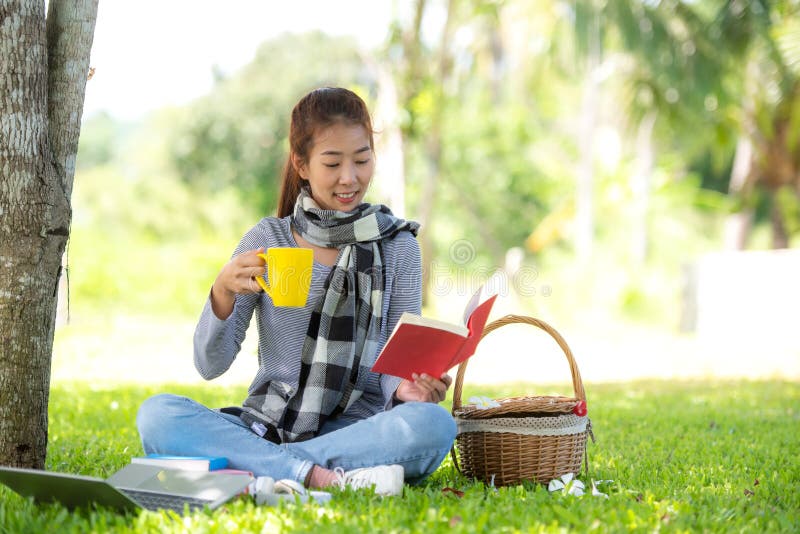 Young people reading book and drinking coffee after working and education on laptop in morning relax at nature garden home