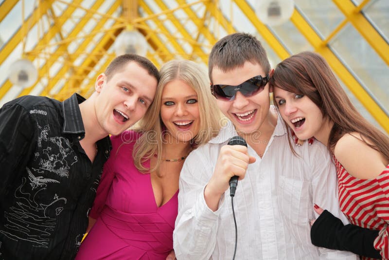 Young people sing in microphone on footbridge