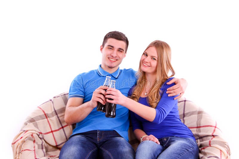 Young people sitting on a sofa and drinking Coca Cola