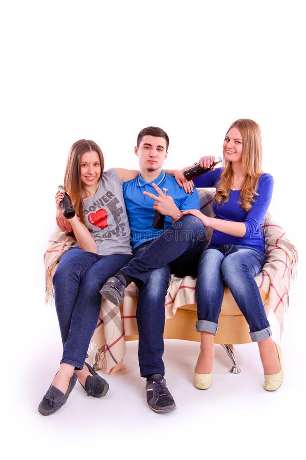 Young people sitting on a sofa and drinking soda