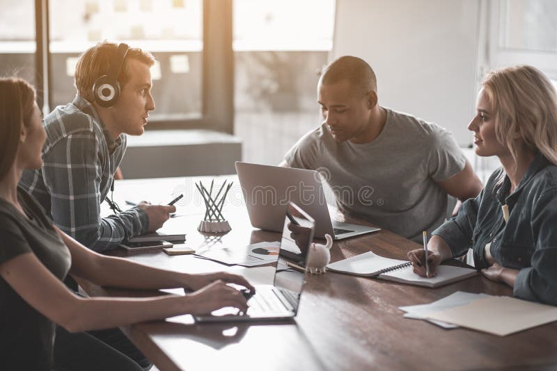 Four students doing group assignment stock images
