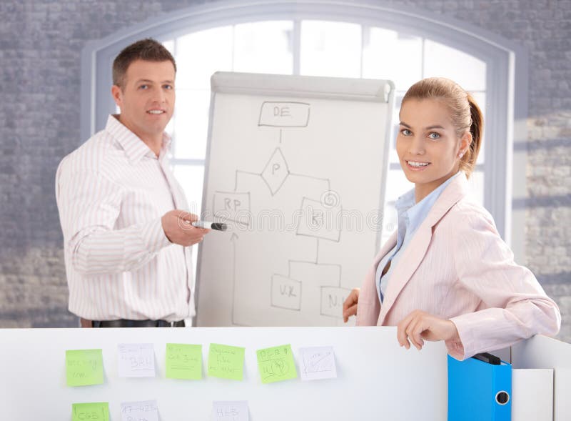 Young people working together in office, using whiteboard, smiling. Standing file folder stock images, royalty-free photos and pictures