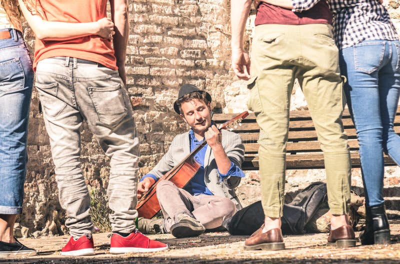 Young people watching street artist performer playing guitar royalty free stock photo Young people watching street artist performer playing guitar royalty free stock photo