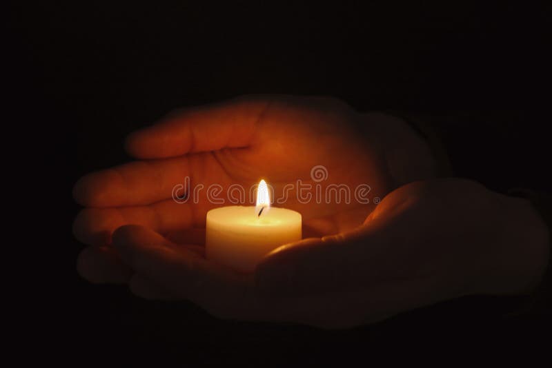 Young person holding burning candle royalty free stock images