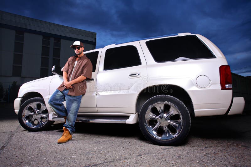Young person standing next to SUV royalty free stock photo