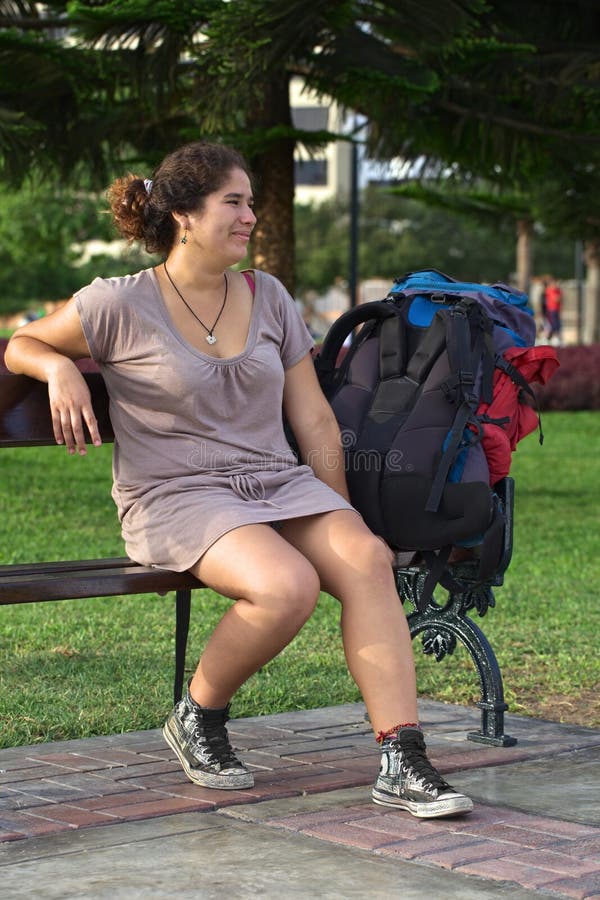 Young Peruvian Woman on Bench with Backpack stock photo