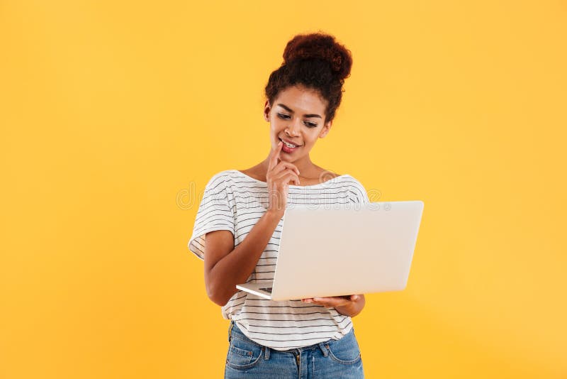 Young positive cool lady with curly hair using laptop isolated