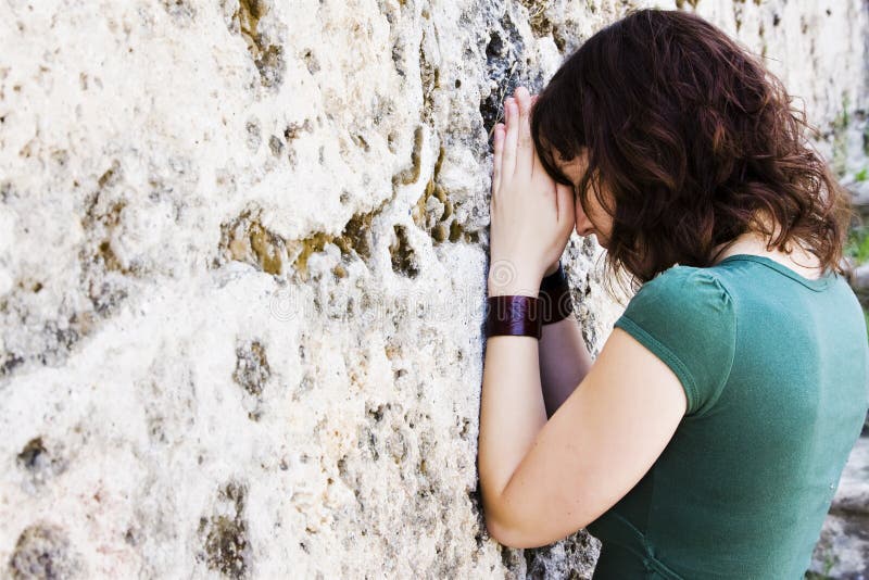 Young prayer against wall